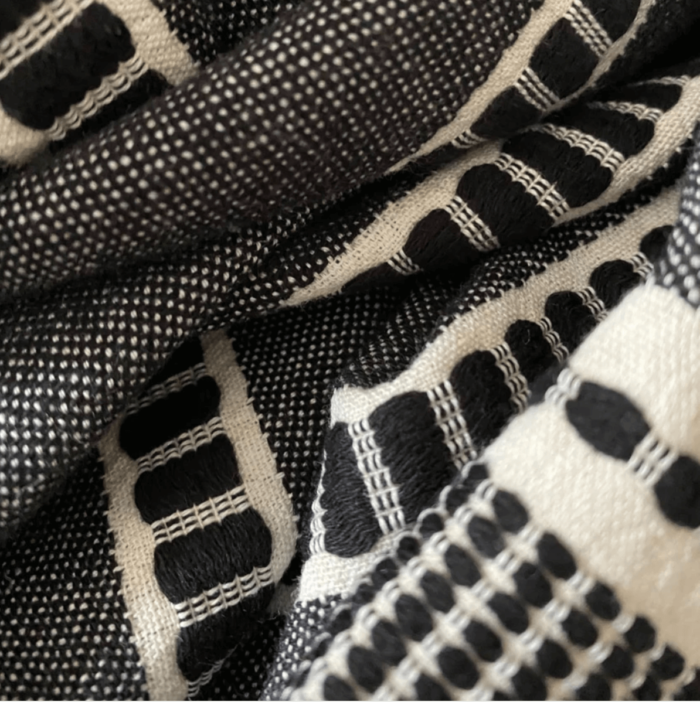 Sefa is a super soft deluxe and versatile peshtemal that has been traditionally loomed by master weavers from GOTS certified organic cotton. Size: 90 x 170 cm. Seen here in Noir close up.